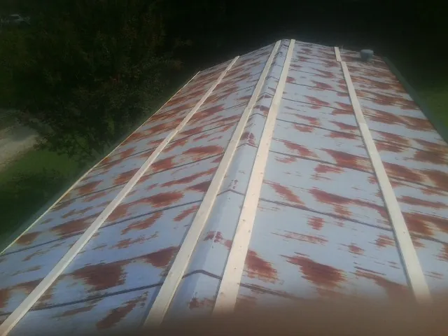 Rusted metal roof panels with new wood purlins before replacement — Storm Damage Roof Repair in Daphne by Roofing Brothers