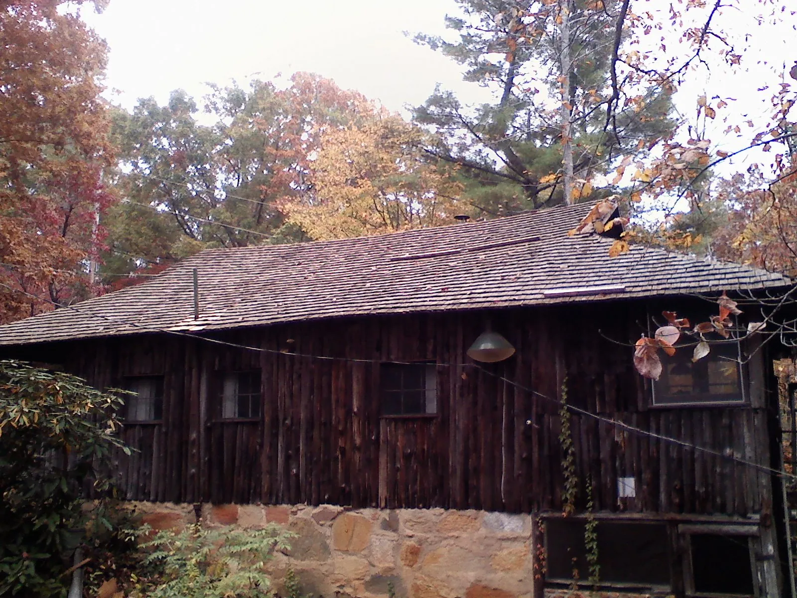 Weathered wood shake roof on a rustic board sided cabin in Daphne