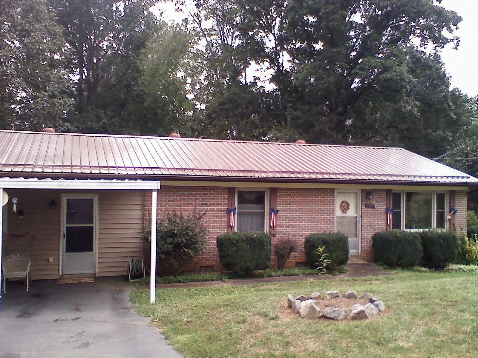 Bronze metal roof and carport on a brick ranch home — Roof Repair work by our crew in Daphne