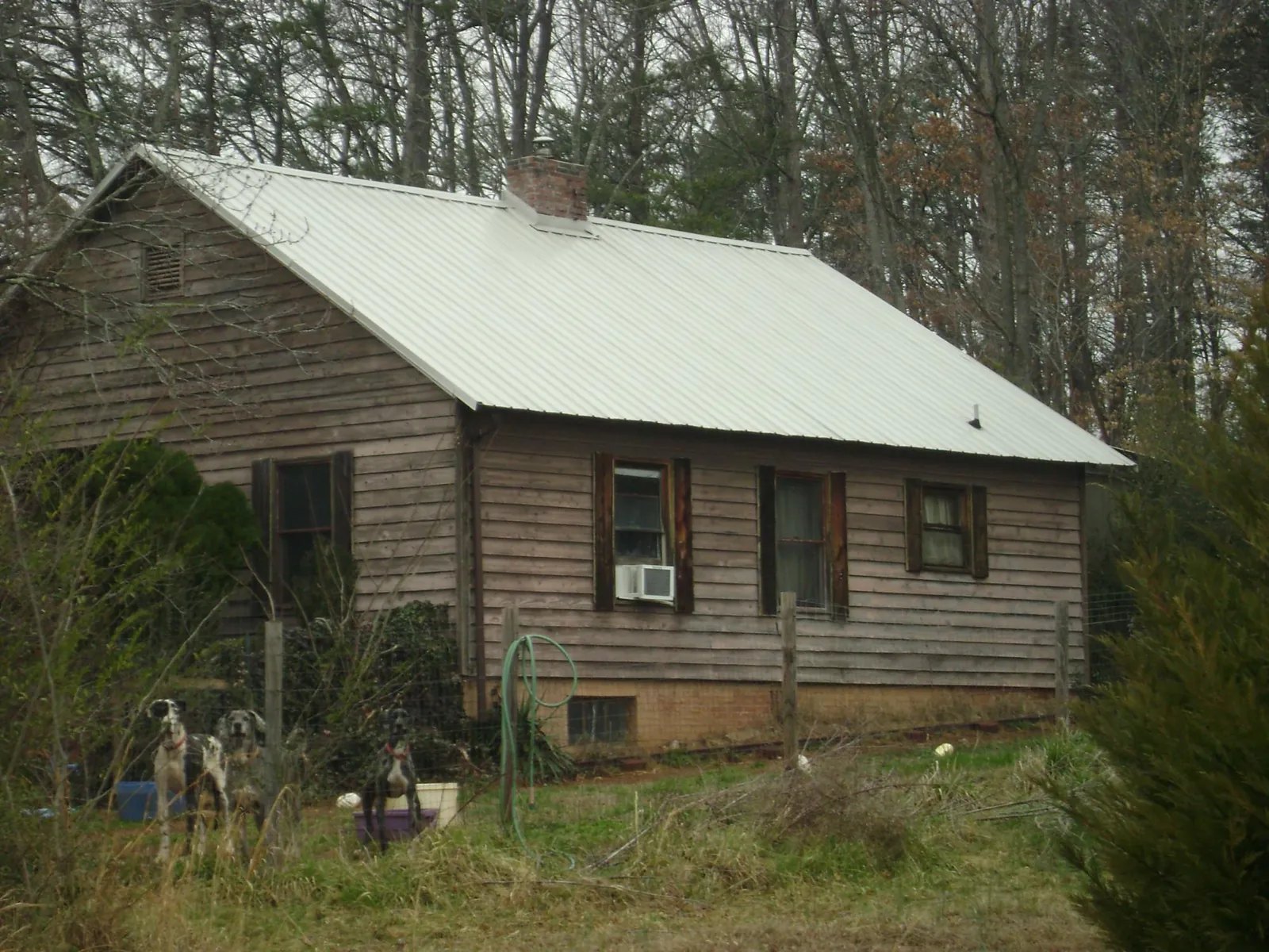 White metal roof on an old wood sided farmhouse, from a Metal Roof Installation job in Daphne